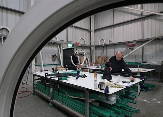 Staff in factory cutting window frames into shape